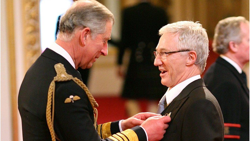 Paul O'Grady being made a Member of the Order of the British Empire by the then Prince of Wales (now King Charles III)