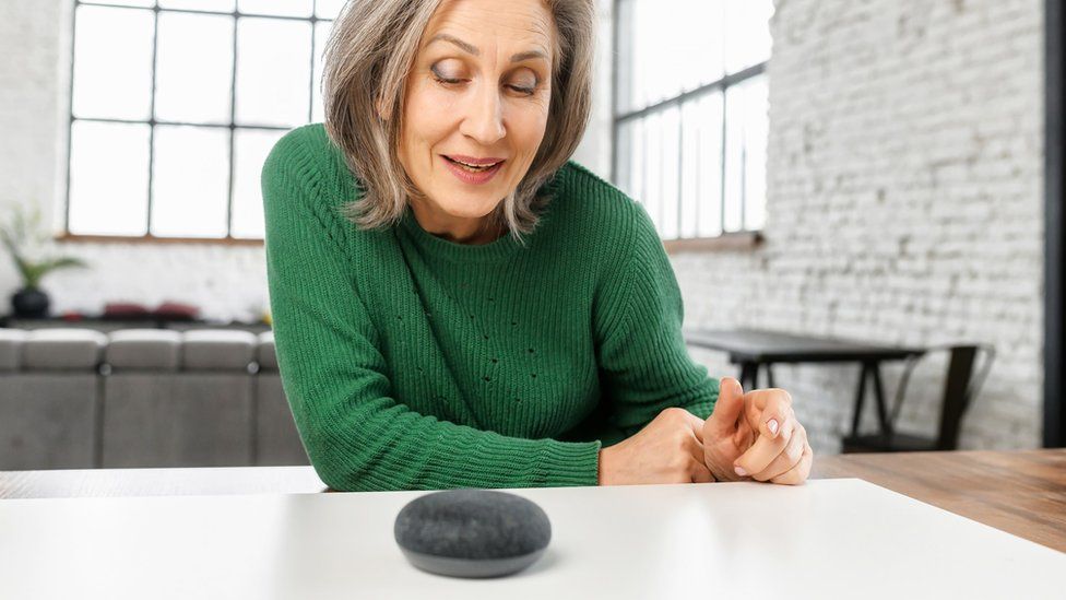 older woman interacting with smart speaker