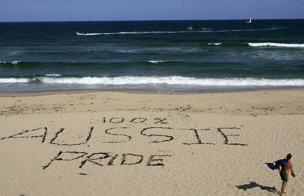 "100% Aussie Pride" written in the sands of Cronulla beach in Sydney