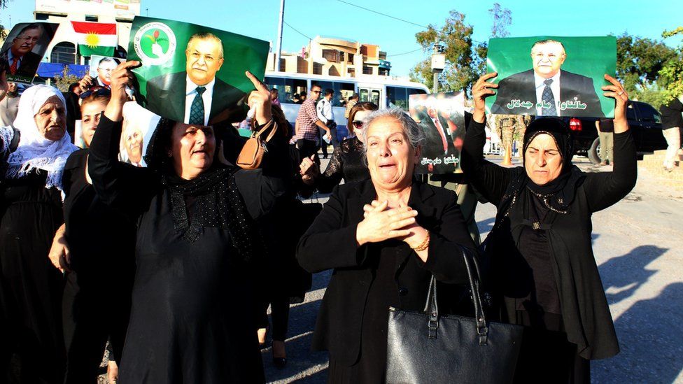 Iraqi Kurdish women carry pictures of former Iraqi President Jalal Talabani as they mourn news of his death at the headquarters of his party, in Sulaimaniya, northern Iraq, on 4 October 2017