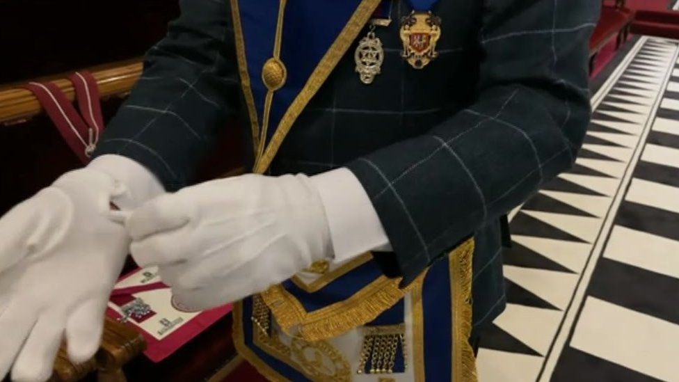 A freemason putting on gloves