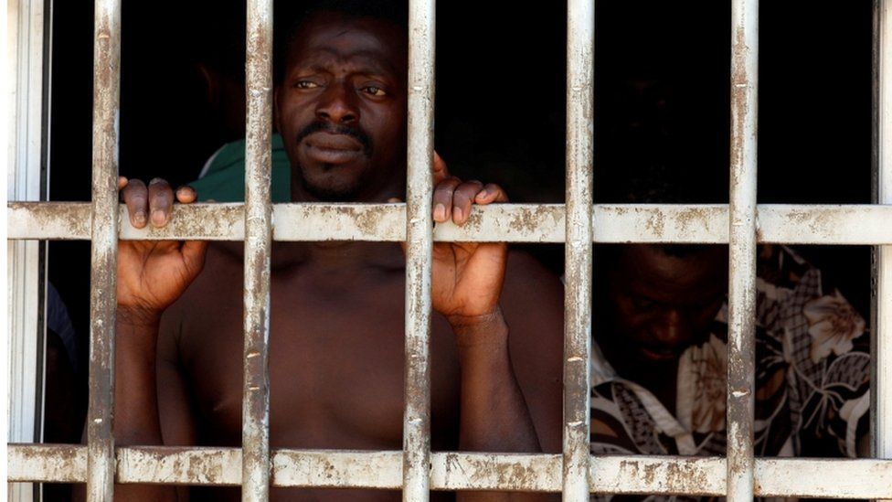 Two migrant men are pictured in detention in Gharyan, Libya