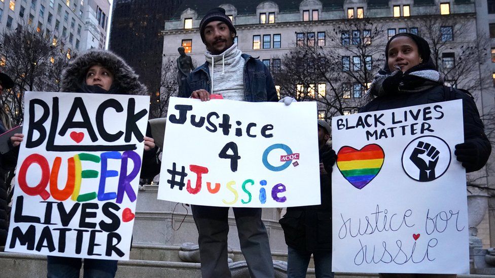 People holding signs saying: "Black queer lives matter" and "Justice 4 Jussie".