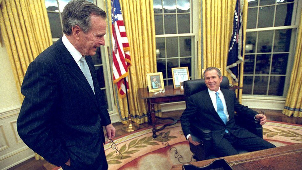 President George W. Bush sits at his desk January 20, 2001 in the Oval Office for the first time on Inaugural Day.
