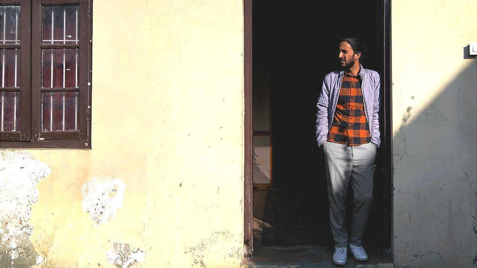 Fahad Shah stands in a doorway.