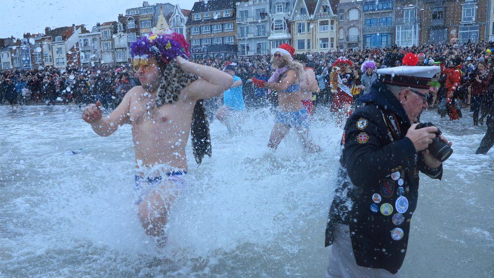 People wearing costumes participate in a traditional New Year's Day swim in Dunkirk, France, 1 January 2018