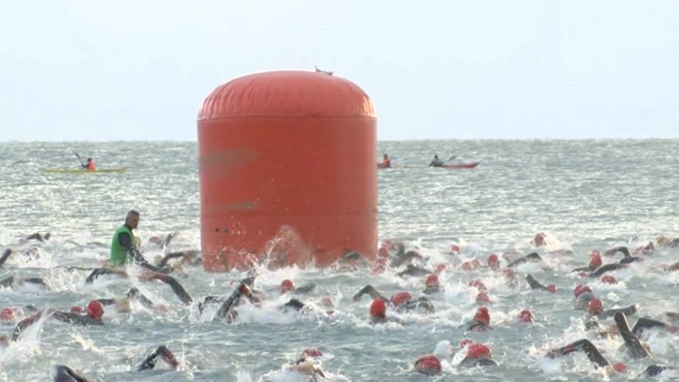 Swimmers swim in Carmarthen Bay