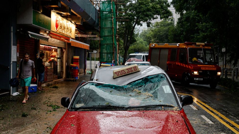 A red Hong Kong taxi's roof is crushed in by falling debris from Typhoon Saola