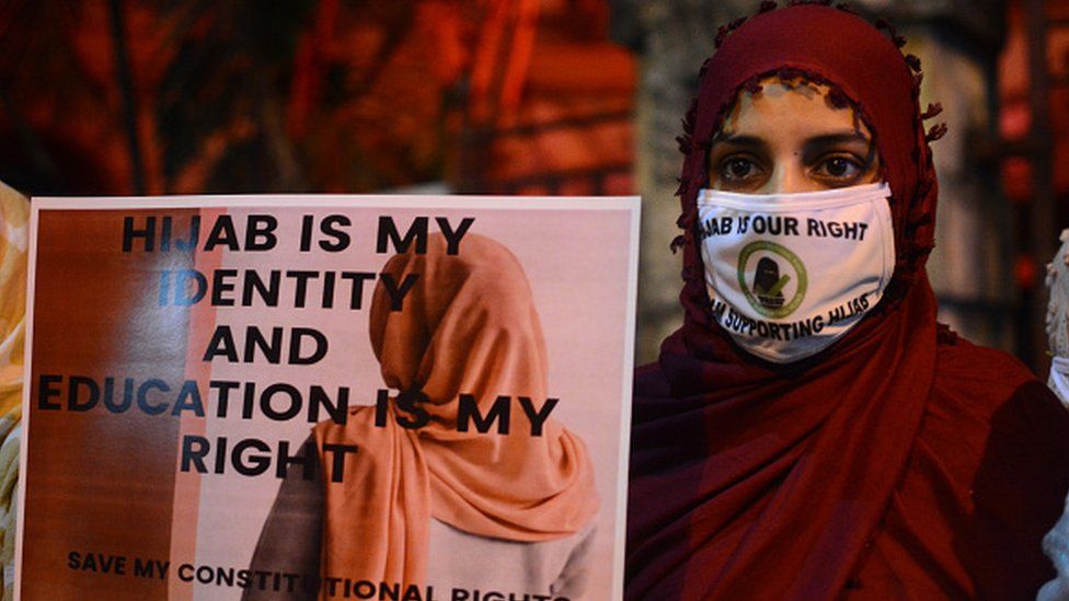 Женщина принимает участие в марше при свечах в Калькутте в знак протеста против запрета Карнатаки на ношение хиджаба в учебных заведениях.