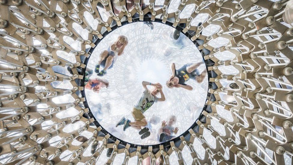 Children looking down through a glass-domed ceiling