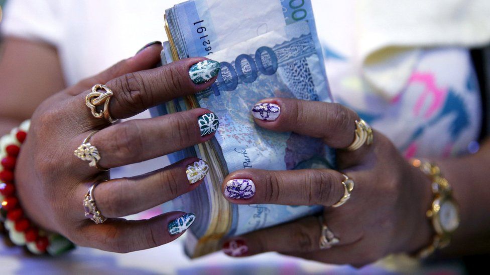 A casino financier wearing rings and with painted fingernails