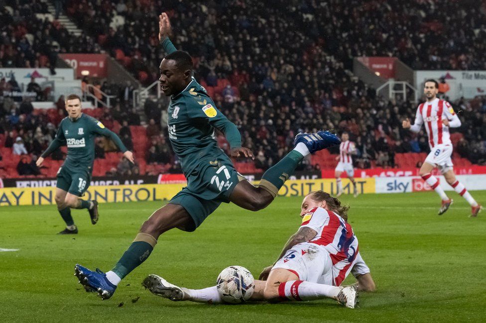 Middlesbrough's Marc Bola is tackled by Stoke City's Ben Wilmot during the Sky Bet Championship match between Stoke City and Middlesbrough at Bet365 Stadium on December 11, 2021 in Stoke on Trent