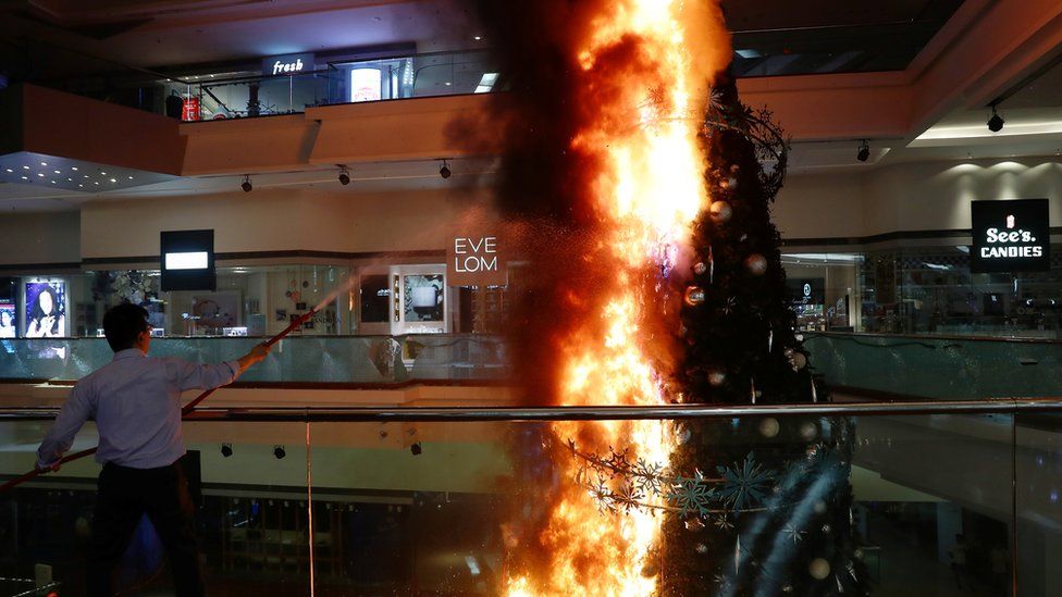 A Christmas tree inside a shopping mall on fire