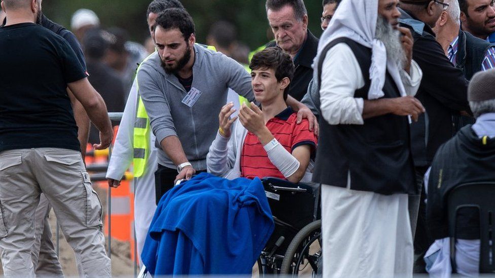 Zaid Mustafa in a wheelchair at the funeral for his father and brother