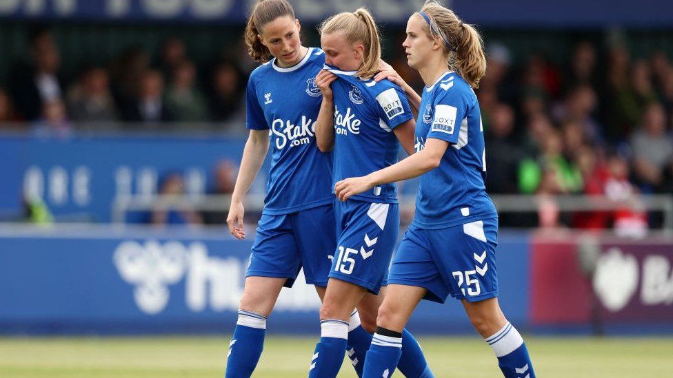 Aggie Beever-Jones of Everton, in tears, surrounded by two team-mates as she walks off the pitch
