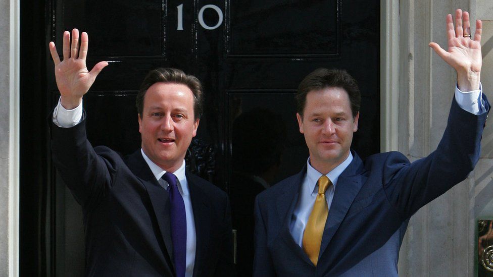 Cameron and Clegg waving to the media on the steps of No 10 Downing Street