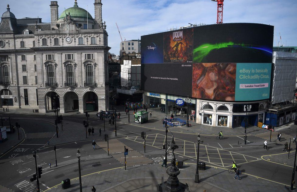 Piccadilly Circus in central London is seen at lunch time on March 21, 2020, a day after the British government said it would help cover the wages of people hit by the coronavirus outbreak as it tightened restrictions to curb the spread of the disease.