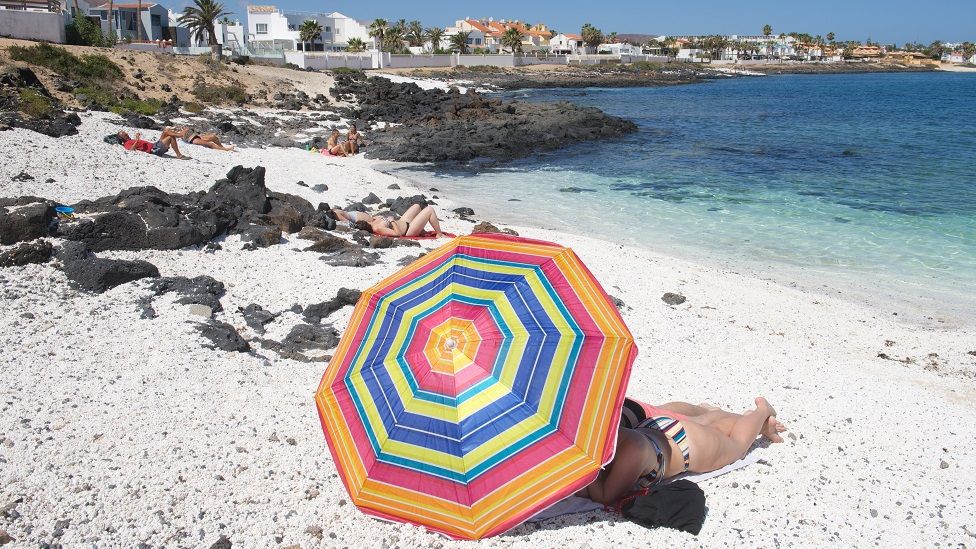 People enjoy a warm day at the beach of Corralejo, Fuerteventura, Canary Islands