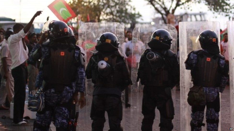 Policemen face opposition supporters during a protest to demand the resignation of Maldives President Yameen Abdul Gayoom (01 May 2015)