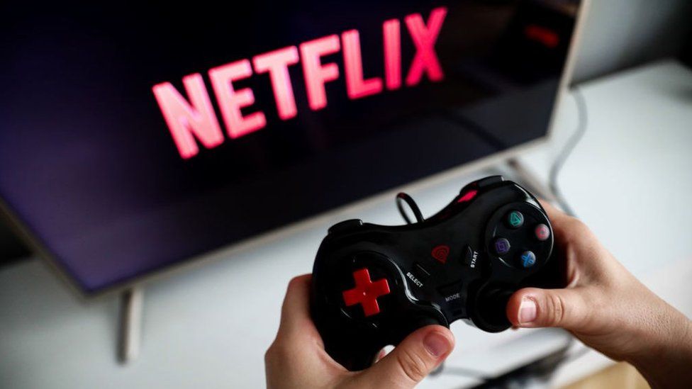 Person using a gaming console with Netflix on screen.