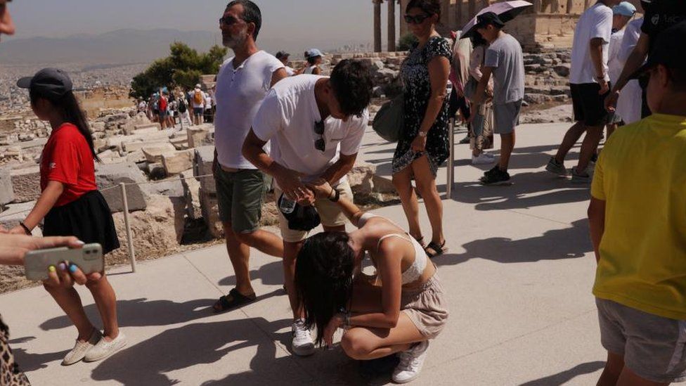 Посетитель пострадал от жары на вершине холма Акрополя во время сильной жары в Афинах, Греция, 14 июля