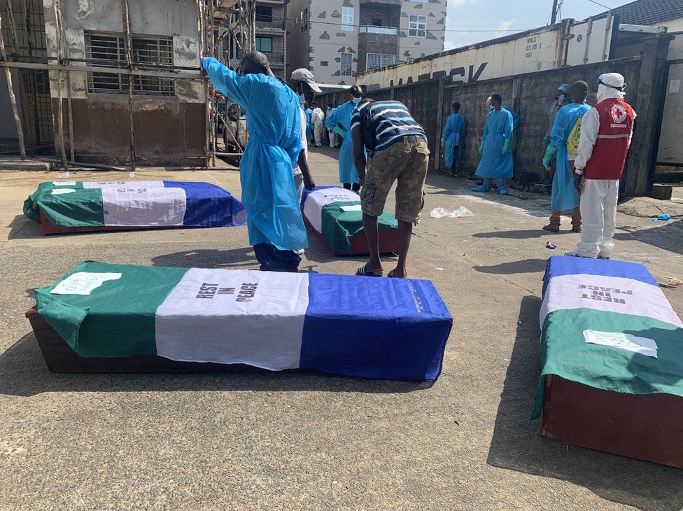 People drape coffins in the national flag