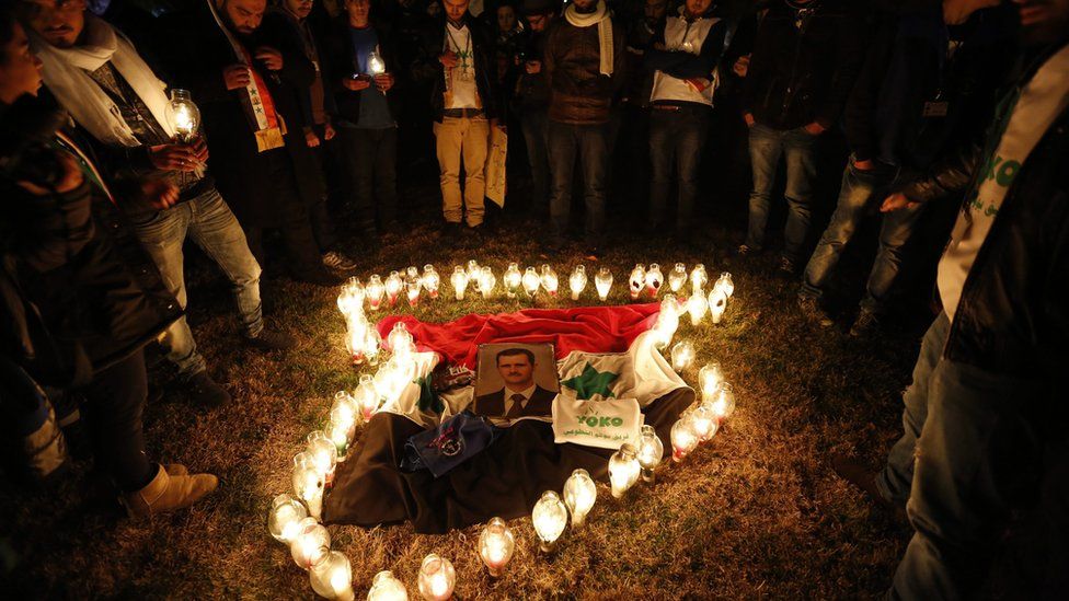 Syrians place candles, around the picture of Syrian President Bashar Assad, in the shape the Syrian map during a vigil fro peace at the Ummayyad Square in Damascus, Syria, 30 December 2016