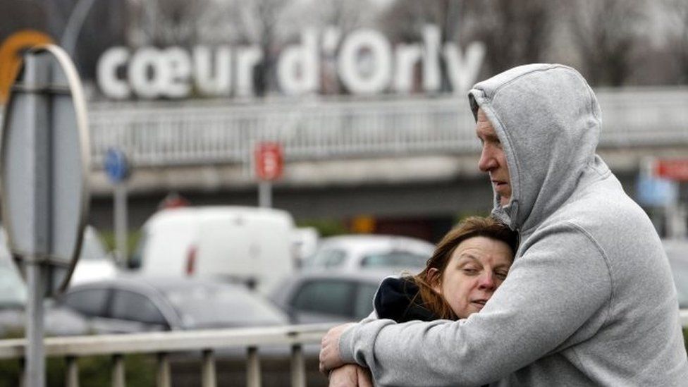 Travellers hug outside Orly airport (18 March 2017)