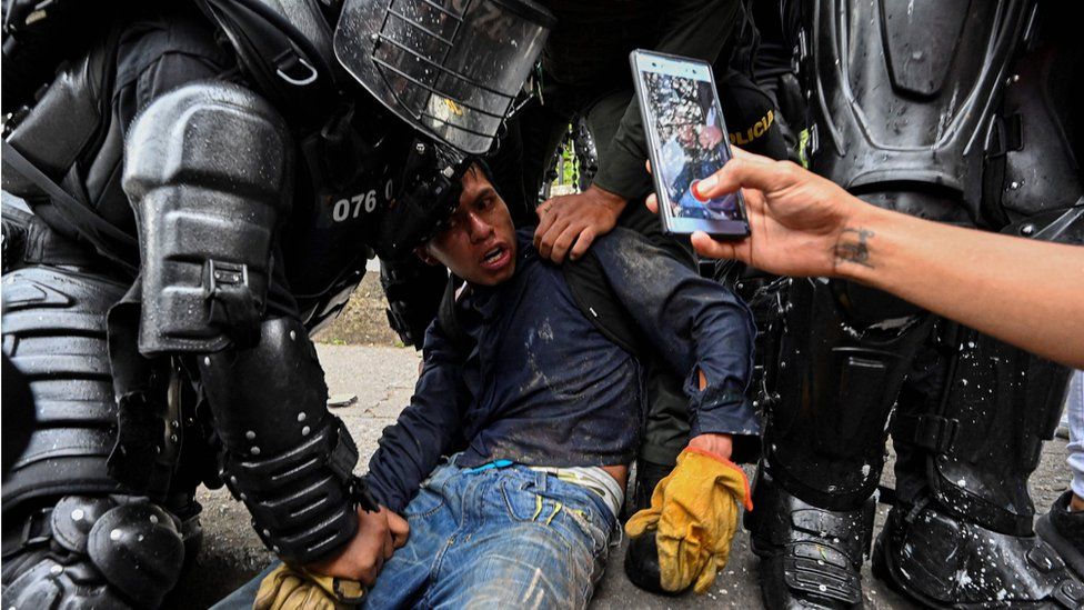 Колумбийские полицейские арестовывают демонстранта во время акции протеста против правительства в Кали, Колумбия, 10 мая