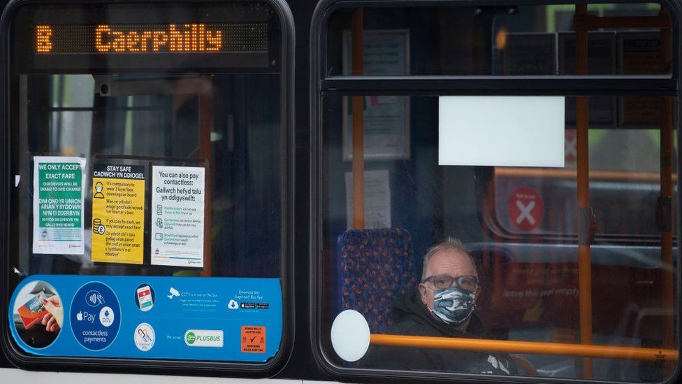 A bus in Caerphilly with a passenger wearing a mask