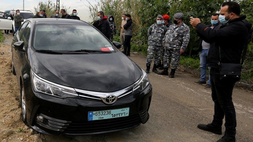 People gather near the car in which Lokman Slim was found killed, in Addousieh, Lebanon (4 February 2021)