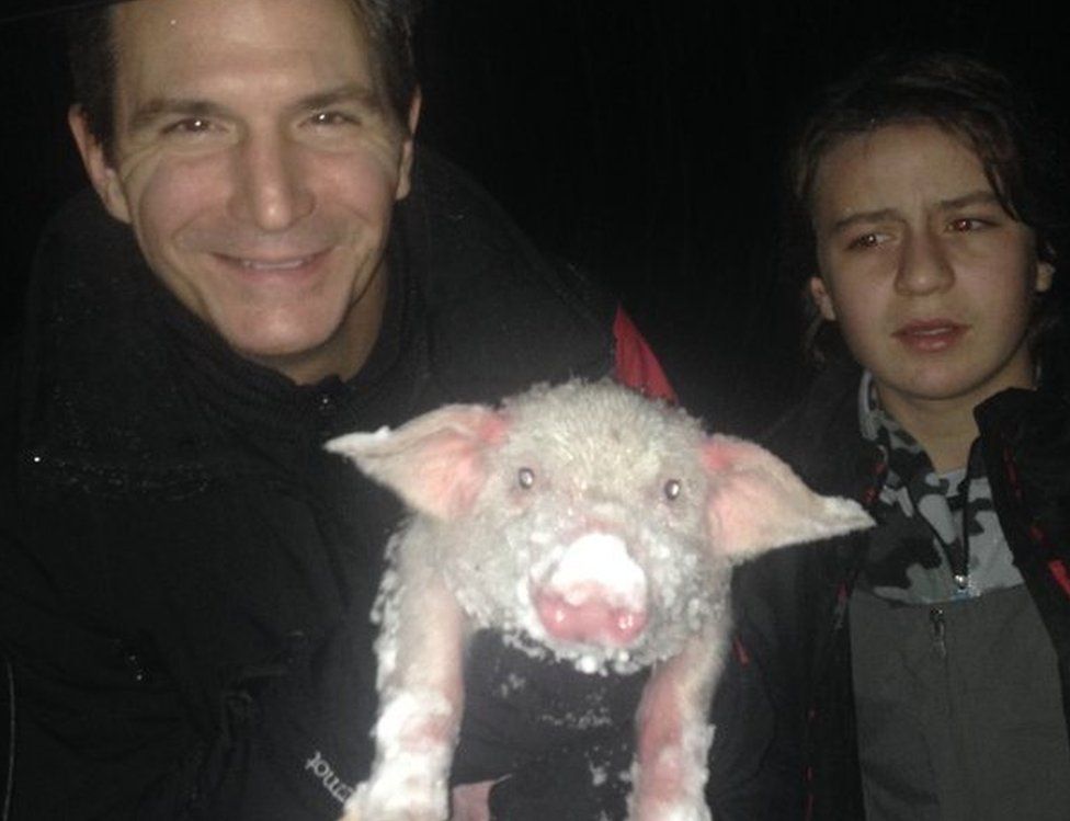 Perry Smith and his son with an icy piglet