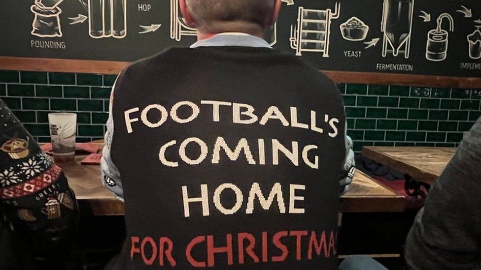 England supporter Chris Sprackman wears a jumper that says 'Football's coming home for Christmas'