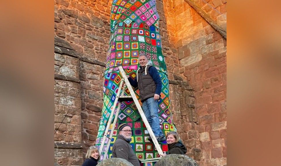 Volunteers making a knitted tree