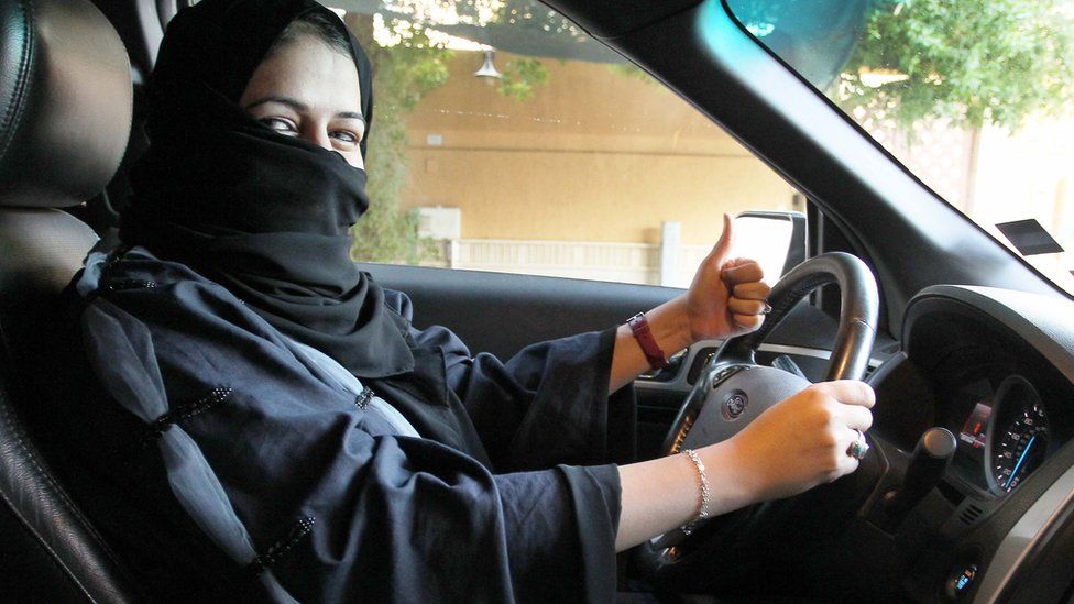 A woman gives a thumb up as she sits behind the wheel of a car in Riyadh, Saudi Arabia, 27 September 2017
