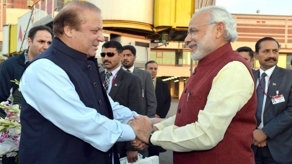 A handout photograph released by the Indian Press Information Bureau (PIB) on 25 December 2015 of Indian Prime Minister Narendra Modi (R) being welcomed by the Prime Minister of Pakistan, Nawaz Sharif (L), at the airport in Lahore, Pakistan, 25 December 2015