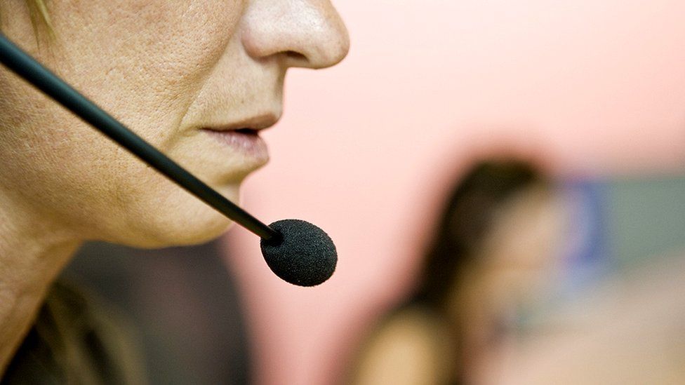 An anonymous woman wearing a headset in an office