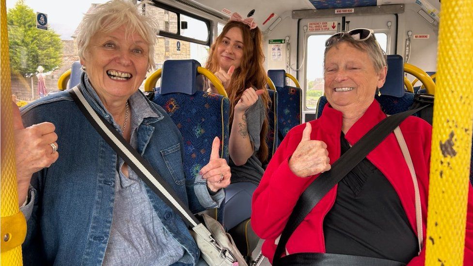 Bus passengers with their thumbs up