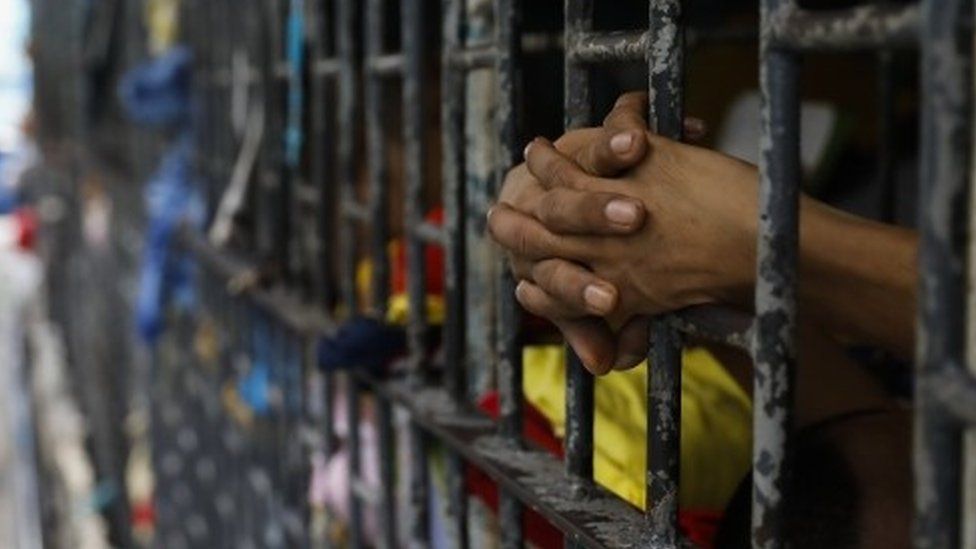 An inmate holds on to cell bars in the Philippines (20 October 2017)