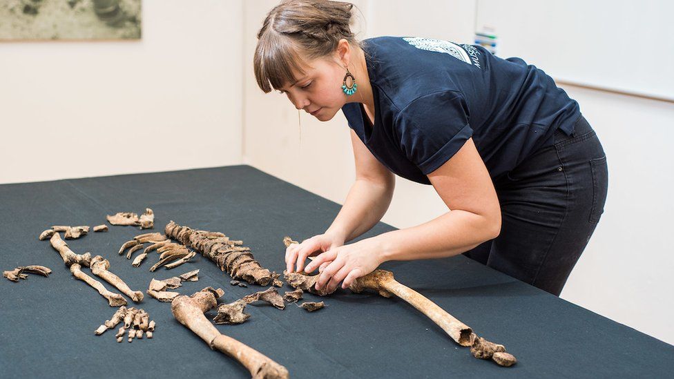 Team member Clara Alfsdotter arranges the remains of one victim of the Sandby Borg massacre