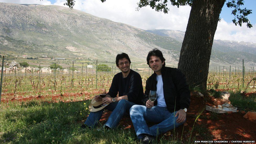 Karim and Sandro Saade enjoy a glass of wine in the shade of a tree