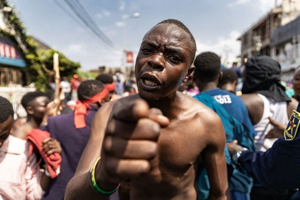A demonstrator gestures as with others tries to reach the border between Democratic Republic of Congo and Rwanda during a protest in Goma on June 15, 2022. Several thousand people demonstrated on Wednesday in Goma, on the border with Rwanda, in the east of the Democratic Republic of Congo (DRC), to denounce "Rwandan aggression" and express their support for the Congolese army, in a context of maximum tension between Kinshasa and Kigali.