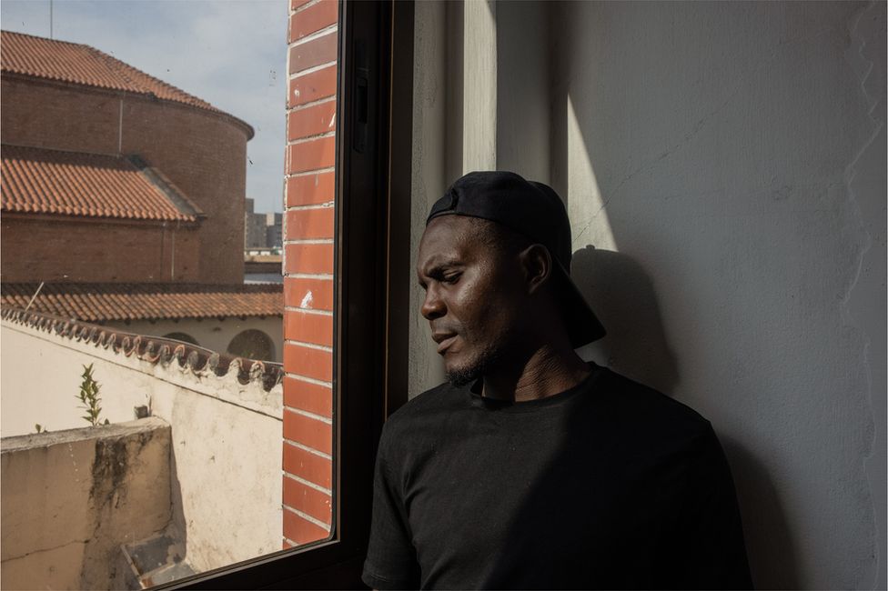 Roman Friday stands by a window in São Paulo.