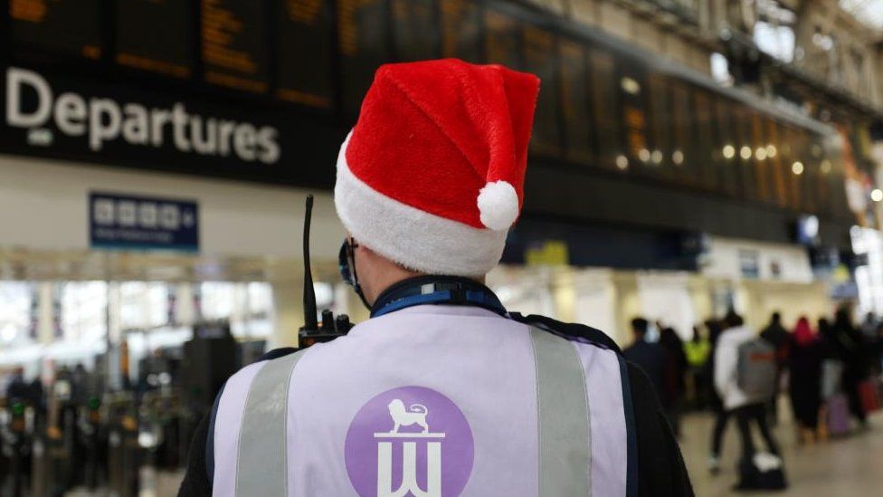 A staff member at London's Waterloo station wears a Christmas hat
