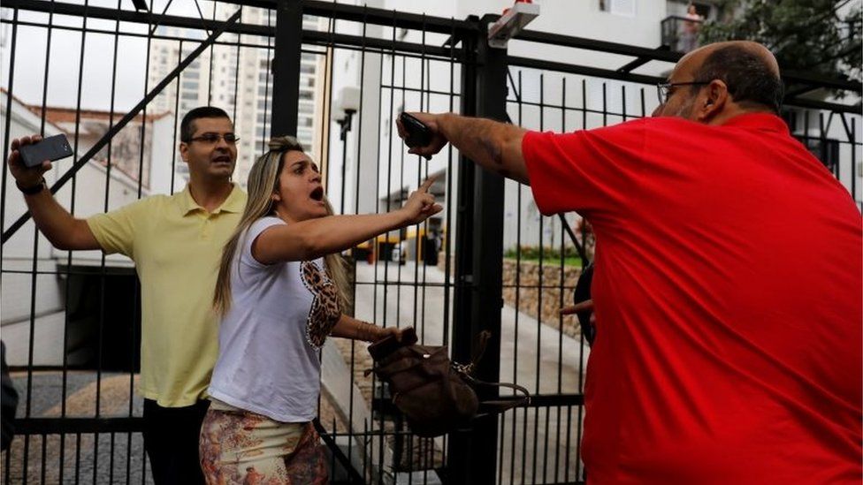 Supporters of Jair Bolsonaro (left) clash with a backer of the Workers' Party