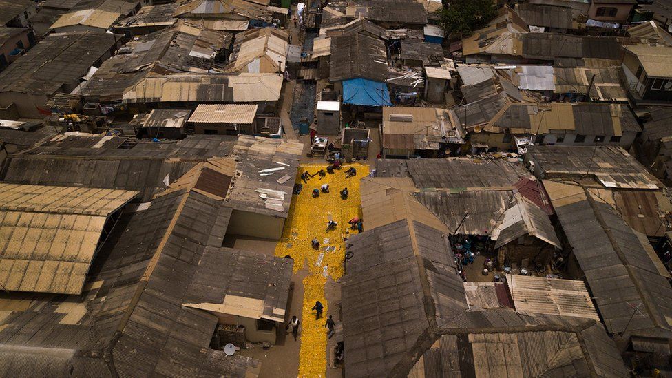 Aerial shot of yellow tapestry created by artist Serge Attukwei Clottey on roads in La - Accra, Ghana