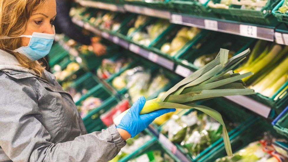 Woman looking at fruit and veg in store