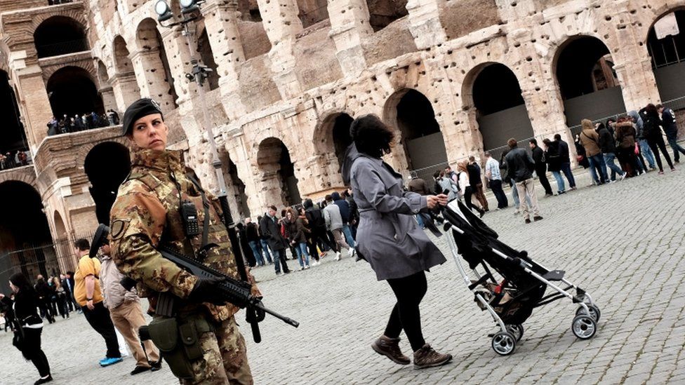 An Italian soldier stands guard outside the Colosseum during a patrol in Rome on 23 March 2016