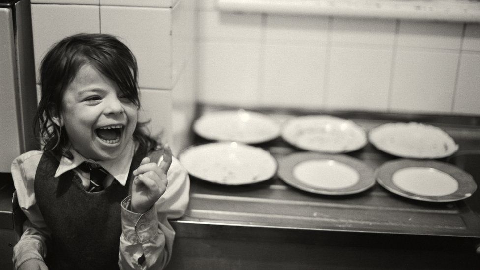 Child laughing near empty plates