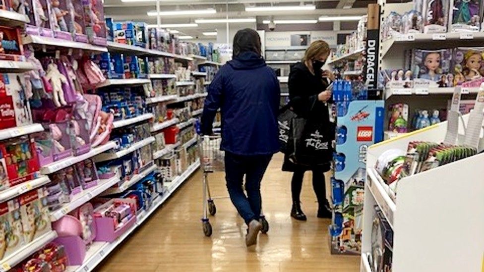 People shopping in supermarket aisle